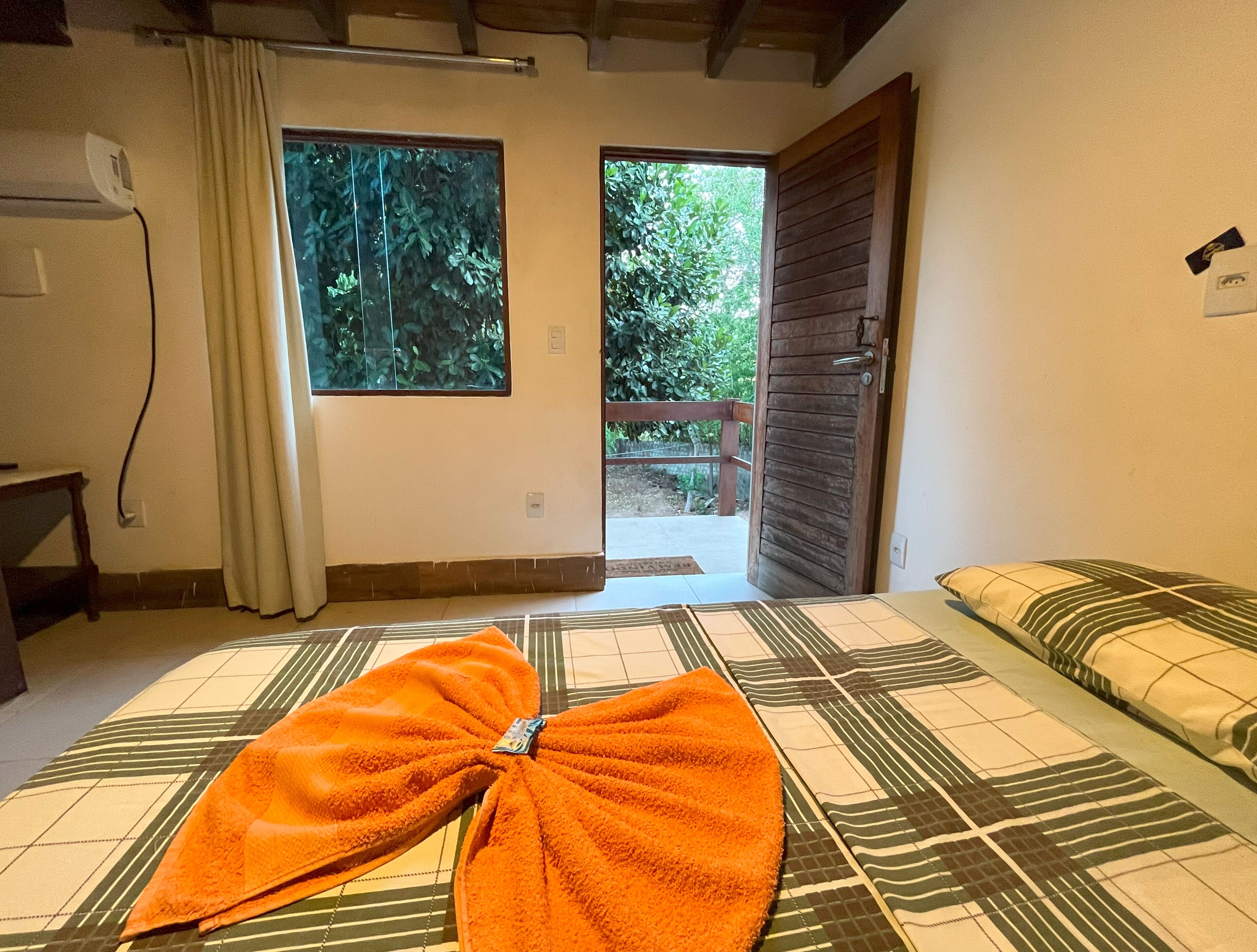 A room with a bed, a window, and a door leading outside.