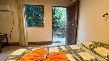 A room with a bed, a window, and a door leading outside.