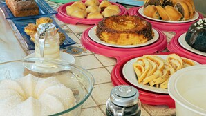 A buffet table with various food items and a coffee maker. - Pousada em Lençóis Reserva do Dendê (Lençóis)