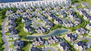 Un quartier résidentiel où les maisons sont disposées selon un plan en forme de grille, avec une allée circulaire centrale et un plan d’eau.