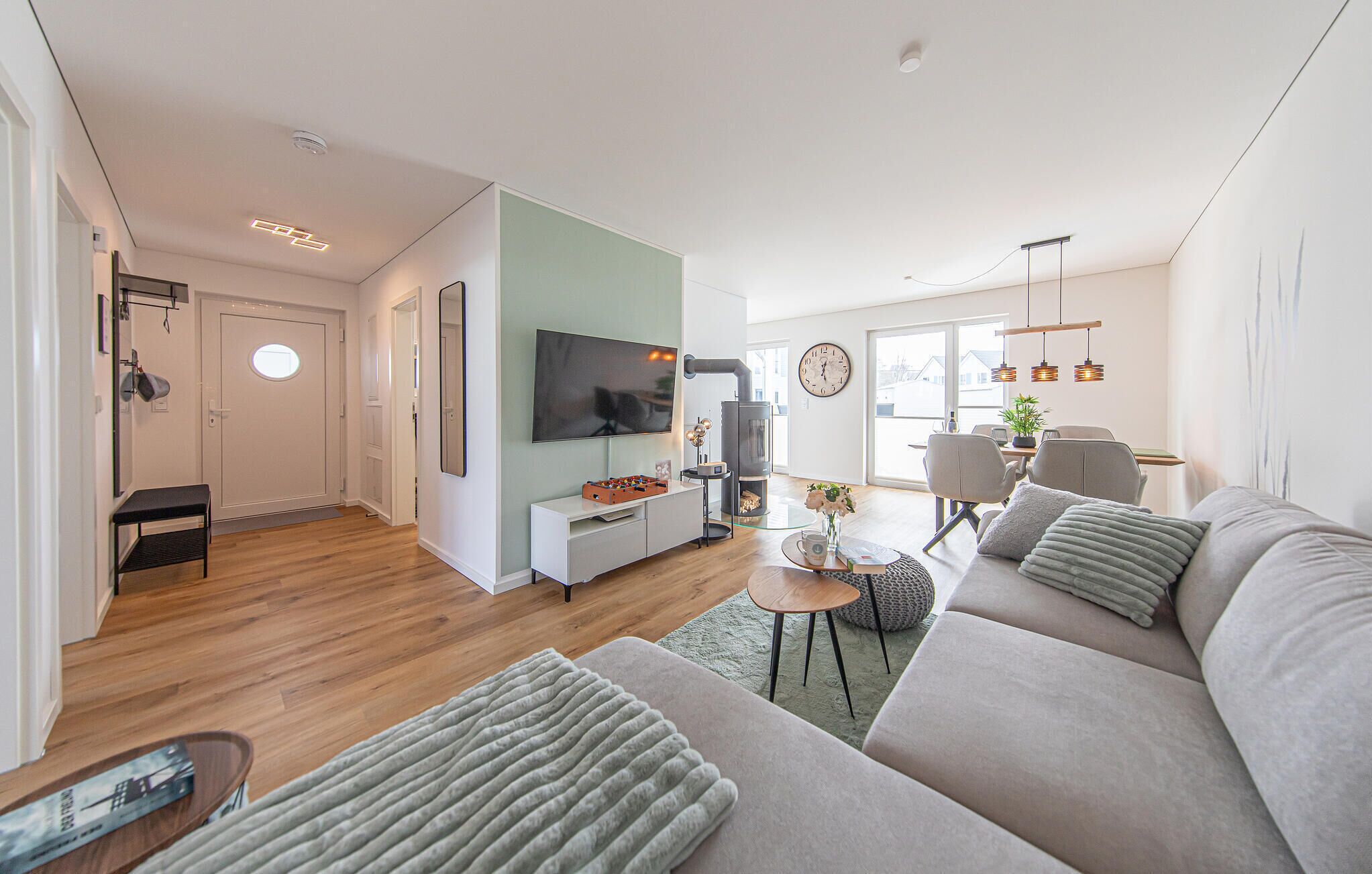 Ein modernes Wohnzimmer mit einer Couch, einem Fernseher und einem Kamin.