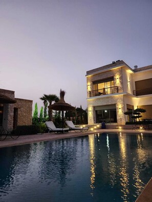 A modern two-story building with a swimming pool, lounge chairs, and a gazebo. - Riad Tammam (Essaouira)