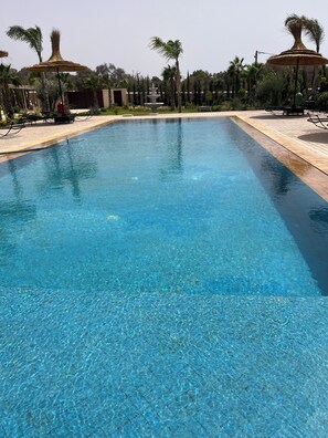 Una piscina al aire libre, una piscina climatizada
