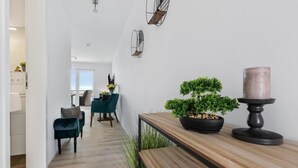A modern interior with a wooden bench, a potted plant, and a candle holder. - Stunning apartment in Olpenitz (Olpenitz)