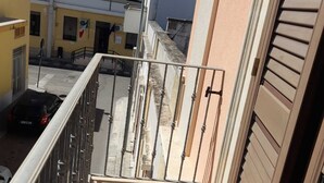 A balcony with a metal railing, a tiled floor, and a view of adjacent buildings. - Holiday Home 'Da Katia' with Private Terrace, Balcony and Air Conditioning (Arnesano)
