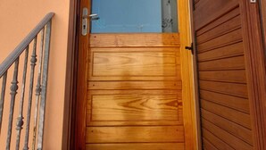 A wooden door with a glass panel, a metal handrail, and a small step leading to the entrance. - Holiday Home 'Da Katia' with Private Terrace, Balcony and Air Conditioning (Arnesano)