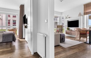 A modern hotel room with a large bed, a desk, a chair, and a TV. - Gorgeous apartment in Olpenitz with sauna (Olpenitz)