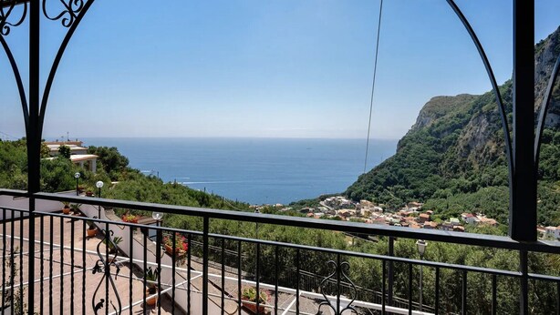 A balcony with a view of the sea and a hillside village. - Villa 'Azzurra' with Sea View, Wi-Fi and Air Conditioning (Massa Lubrense)