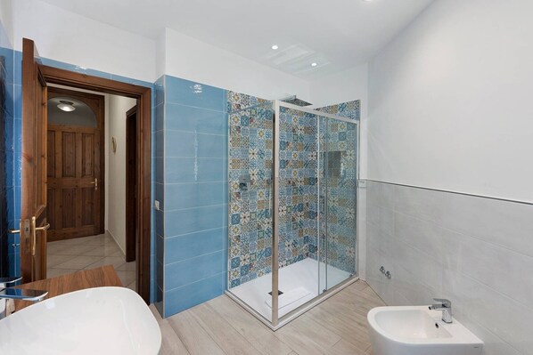 A bathroom with a shower, a bathtub, and a toilet.