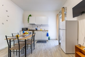 Eine moderne Küche mit weißen Schränken, einem Holztisch und einer eingebauten Mikrowelle.