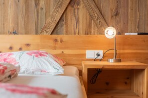 Cabecera de madera con mesita de noche integrada, lámpara e enchufe.