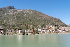 A lakeside hotel with multiple buildings, a mountain backdrop, and a clear sky. - Apartment 'La Busa' with Lake View, Private Garden and Wi-Fi (Masaré)