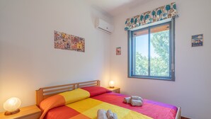 A bedroom with a bed, two bedside tables, a window with a view, and wall art. - Country House 'Casa Susanna' with Mountain View, Wi-Fi and Air Conditioning (avola)