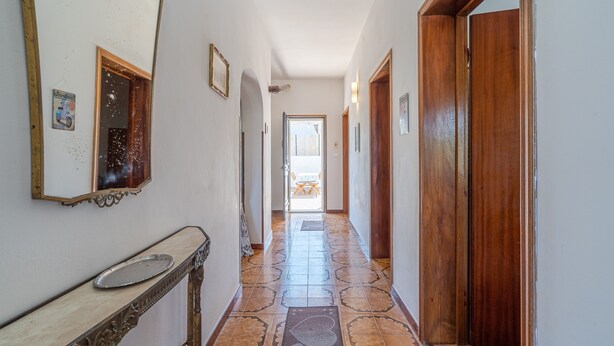A hallway with a mirror, a console table, patterned floor tiles, and wooden doors. - Country House 'Casa Susanna' with Mountain View, Wi-Fi and Air Conditioning (avola)