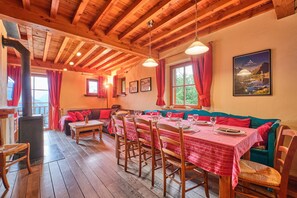 Un interior de madera con una mesa de comedor para cuatro personas, un sofá y una chimenea.