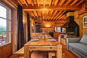 Ein Holzesstzimmer für sechs Personen mit Blick auf Küche und Wohnbereich.