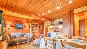 A wooden cabin interior with a dining area, kitchen, and living space. - Chalet 'Il Fera Beau Demain' with Mountain View, Private Terrace and Wi-Fi (Villard-Reculas)