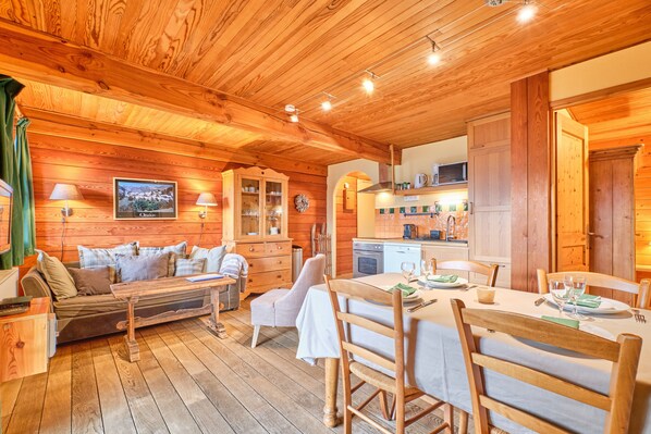 A wooden cabin interior with a dining area, kitchen, and living space. - Chalet 'Il Fera Beau Demain' with Mountain View, Private Terrace and Wi-Fi (Villard-Reculas)