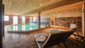 An indoor swimming pool with a wooden ceiling, tiled walls, and a lounge area with a bench and a wheelchair. - Chalet 'Il Fera Beau Demain' with Mountain View, Private Terrace and Wi-Fi (Villard-Reculas)