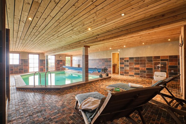 An indoor swimming pool with a wooden ceiling, tiled walls, and a lounge area with a bench and a wheelchair. - Chalet 'Il Fera Beau Demain' with Mountain View, Private Terrace and Wi-Fi (Villard-Reculas)