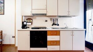 A compact kitchen with white cabinets, a black dishwasher, and a sink.