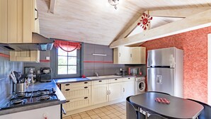 Cucina con piano cottura, forno a microonde, frigorifero e lavello.