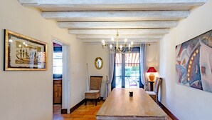 Un'area pranzo con un tavolo in legno, sedie, un lampadario e opere d'arte alle pareti.