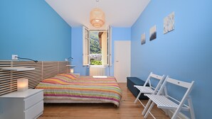 A bedroom with a bed, bedside tables, a window, and a view of greenery. - Le Clos du Casino, T3 "Le Céciré" for 4 to 6 guests (Bagnères de Luchon)