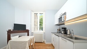 A compact kitchen with a dining area, a built-in microwave, and a coffee maker.
