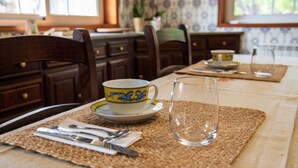 A dining table with a placemat, a cup, a glass, and cutlery.