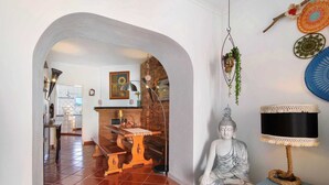 Een kamer met een Boeddhabeeld, een lamp en een wand met decoratieve objecten.