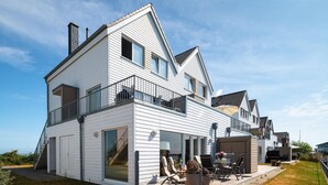 Et toetagers hus med balkon, garage og terrassemøbler.