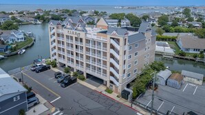 A multi-story hotel with balconies, located near a waterfront.