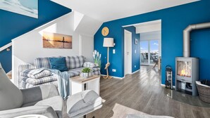 Una sala de estar moderna con una pared azul destacada, un sofá, una mesa de centro y una chimenea.