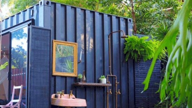 A compact, dark-colored container with a small sink, a framed picture, and a chair. - 5-Acre-Secluded-Farm-Detroit-SwimmingPond-First-Black-Owned-Cider-Mill (Detroit)