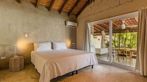 Ein Schlafzimmer mit einem großen Bett, einem Deckenventilator und Blick auf eine Außenpatio.