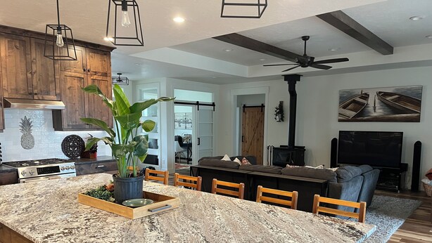 A modern kitchen with granite countertops, wooden cabinets, and a central island with seating. - Comfortable 3-bedroom house with WiFi in Nampa. (Nampa)