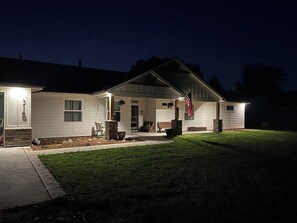 A residential house with a front porch, a flag, and a well-maintained lawn. - Comfortable 3-bedroom house with WiFi in Nampa. (Nampa)