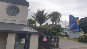 A building with a security camera, a no trespassing sign, and a sign for the Mana Motel.