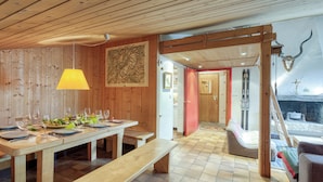 A wooden interior with a dining table set for four, benches, a wooden ceiling, and a ski rack visible in the background. - Apt Le Grenier Ski-in/Ski-out views, sleeps 7, Le Tour (Argentière), France (Le Tour (Argentière))