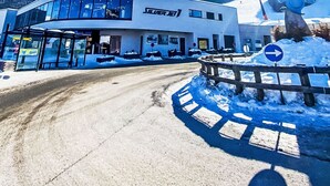 A modern building with a glass facade, a sign reading "SILVER B", and a snow-covered landscape in the background.