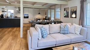 A modern living room with a sofa, dining area, and kitchen. - Melvill by Interhome (Dittishausen)