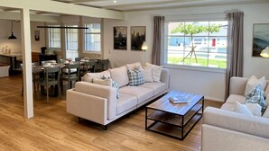 A spacious living area with a sofa set, a coffee table, and a dining area with chairs and a table. - Melvill by Interhome (Dittishausen)