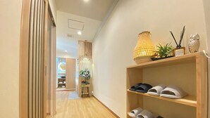 A hallway with wooden flooring, a shoe shelf with slippers, a hanging lamp, and a plant. - G1A#[NEW] Tokyo/Shinjuku-ku/New comfortable guest room/5 min. to Shinjuku on JR line (新宿区)