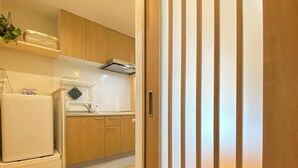 A modern kitchen with wooden cabinets, a built-in oven, and a countertop with a sink. - G1A#[NEW] Tokyo/Shinjuku-ku/New comfortable guest room/5 min. to Shinjuku on JR line (新宿区)