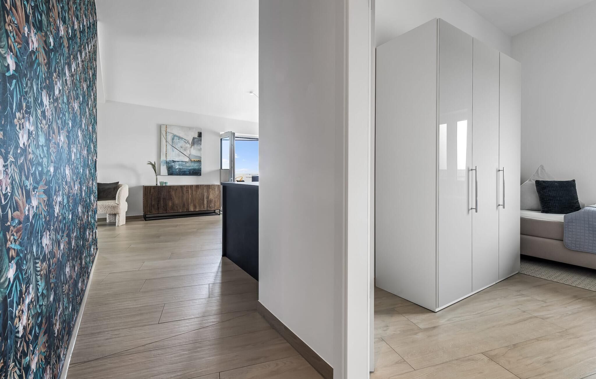 A modern living room with a sofa, a coffee table, and a large wardrobe.