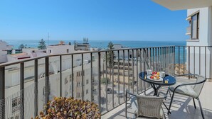 Un balcón con una mesa dispuesta para dos, con vista al mar.