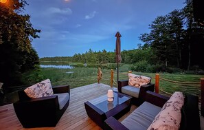 An outdoor seating area with a view of a lake and forest. - 1 bedroom gorgeous home in Figeholm (Figeholm)