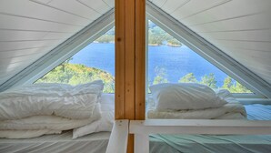 Une chambre avec vue sur un lac et une forêt.