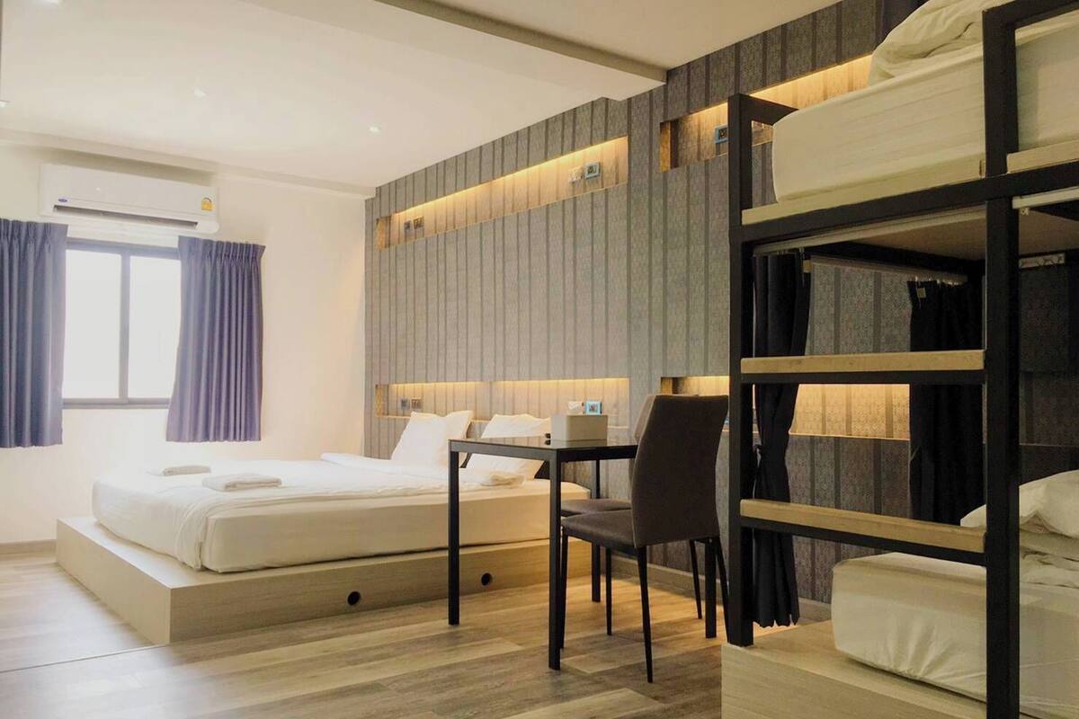 Une chambre d’hôtel moderne équipée d’un lit superposé, d’un bureau et d’une chaise.